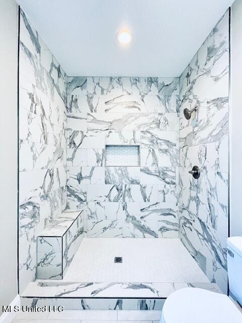 bathroom featuring toilet and tiled shower