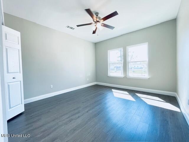 spare room with ceiling fan and dark hardwood / wood-style flooring