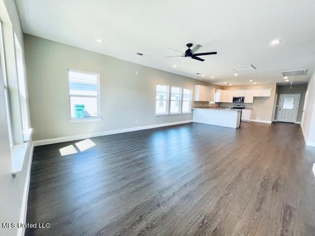 unfurnished living room with dark wood-type flooring and ceiling fan