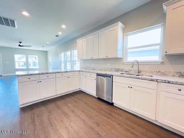 kitchen featuring light stone countertops, sink, white cabinetry, stainless steel dishwasher, and dark hardwood / wood-style floors