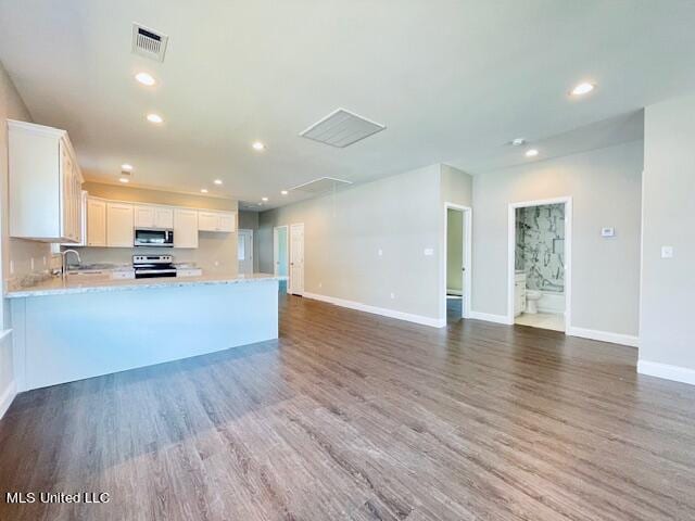 kitchen featuring stainless steel appliances, light stone countertops, dark hardwood / wood-style floors, and white cabinets