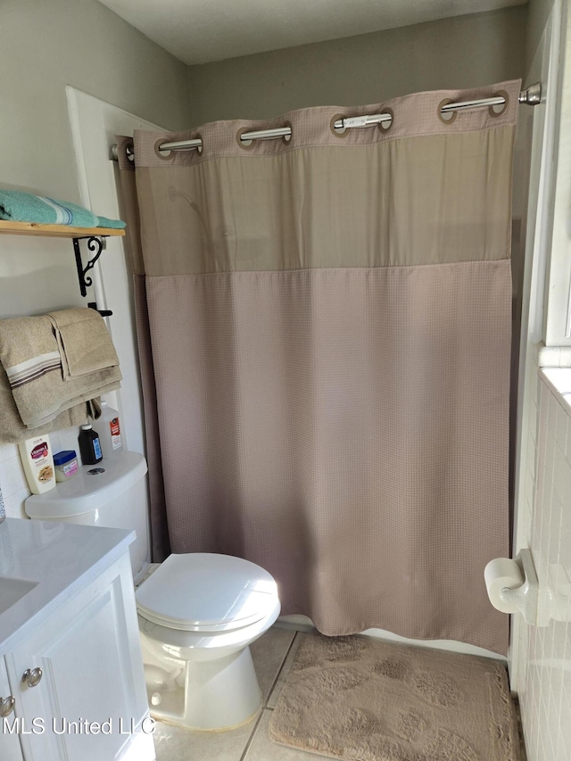 full bathroom with toilet, a shower with curtain, tile patterned flooring, and vanity