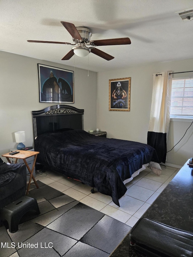 bedroom featuring light tile patterned floors, ceiling fan, visible vents, and baseboards