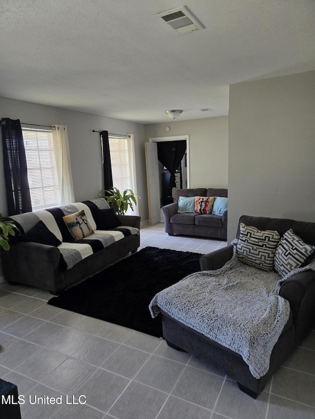 living room featuring light tile patterned floors and visible vents