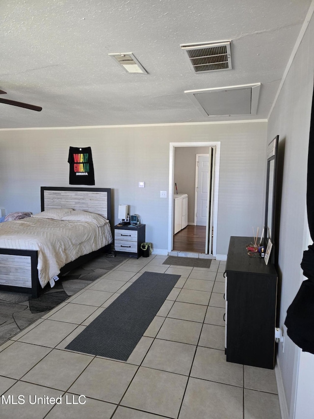 bedroom with attic access, visible vents, separate washer and dryer, and light tile patterned flooring