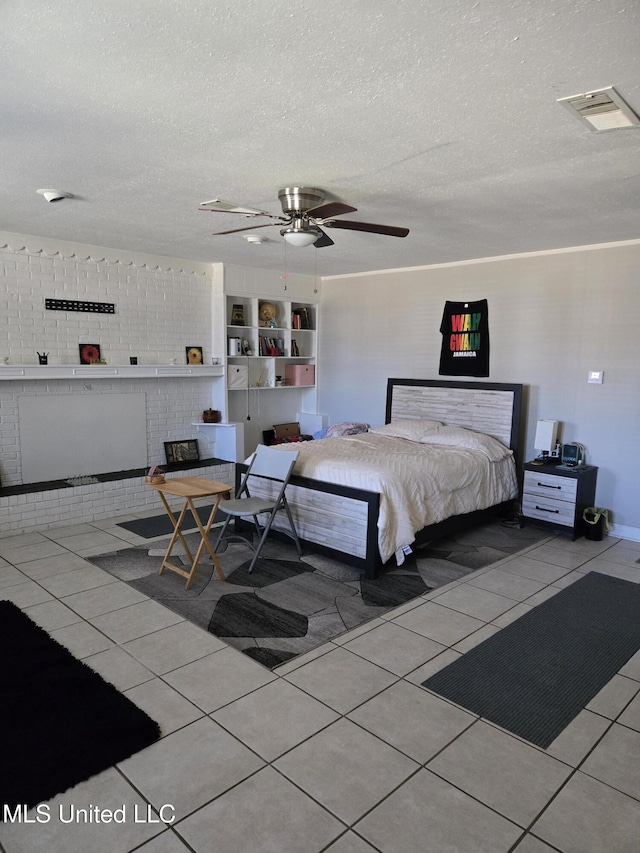 tiled bedroom with a textured ceiling, ceiling fan, and visible vents