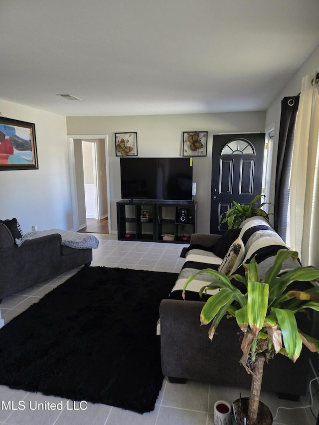 living room featuring light tile patterned flooring and visible vents