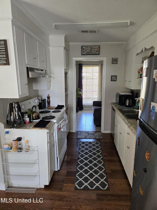 kitchen featuring under cabinet range hood, dark wood-type flooring, white cabinetry, visible vents, and appliances with stainless steel finishes