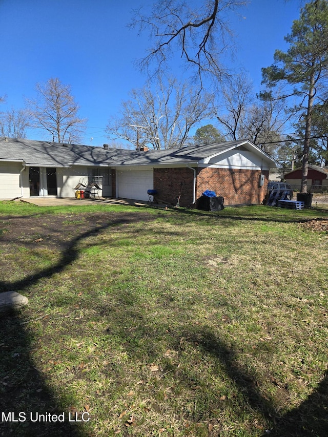 view of front of home with a garage, brick siding, and a front yard