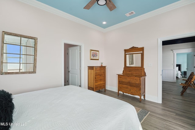 bedroom featuring dark wood-type flooring, ceiling fan, and ornamental molding