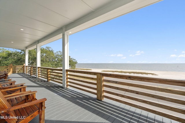 wooden terrace with a view of the beach and a water view