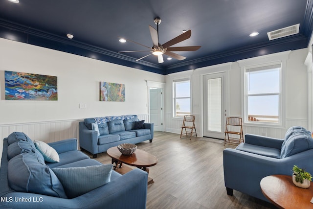 living room with hardwood / wood-style flooring, ceiling fan, and crown molding