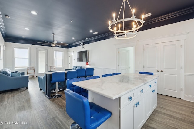 601 E Beach Blvd, Long Beach, MS 39560 - kitchen with open floor plan, crown molding, a chandelier, a kitchen island, and wood finished floors