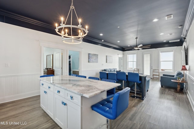 601 E Beach Blvd, Long Beach, MS 39560 - kitchen featuring an island with sink, open floor plan, a wainscoted wall, wood finished floors, and a chandelier