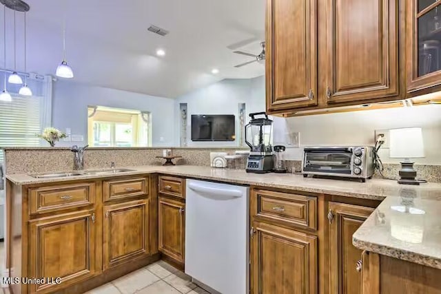 kitchen with light tile patterned floors, sink, light stone counters, dishwasher, and hanging light fixtures