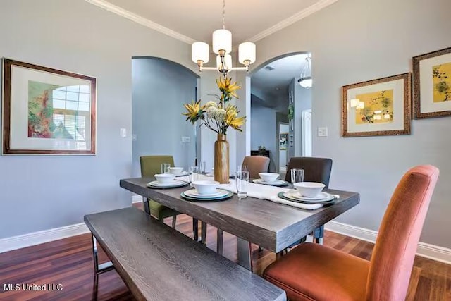 dining space featuring ornamental molding, dark wood-type flooring, and an inviting chandelier