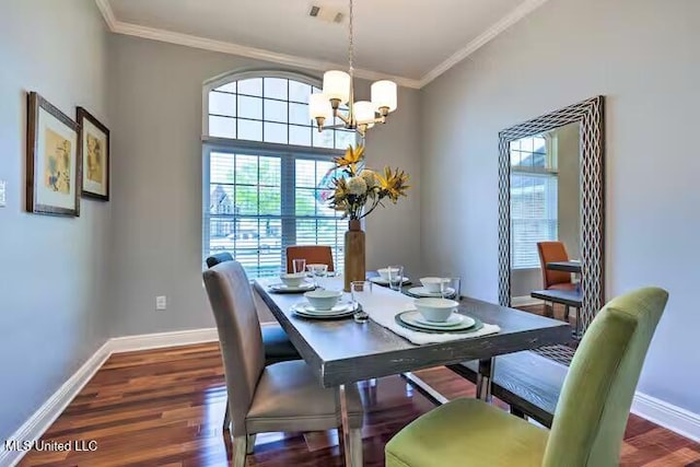 dining room with dark hardwood / wood-style flooring, crown molding, and a chandelier