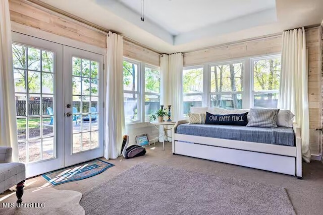 sunroom / solarium with a raised ceiling, french doors, and a healthy amount of sunlight