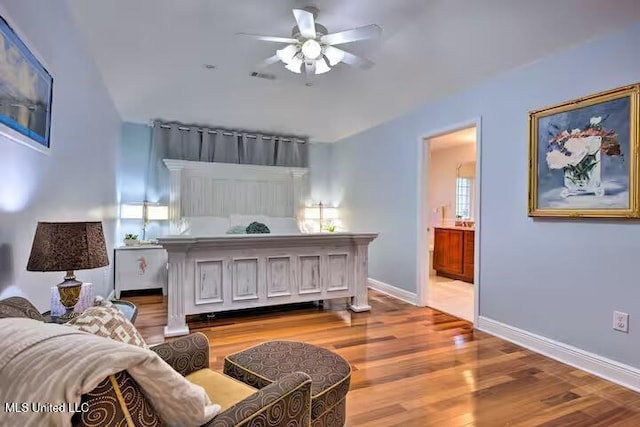 bedroom with wood-type flooring, connected bathroom, and ceiling fan