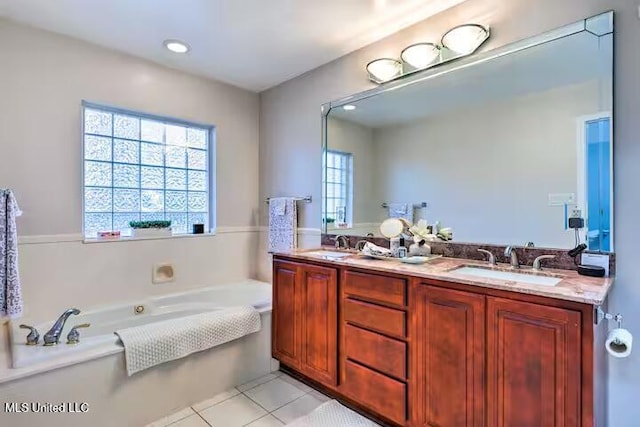 bathroom with a tub, tile patterned floors, and vanity