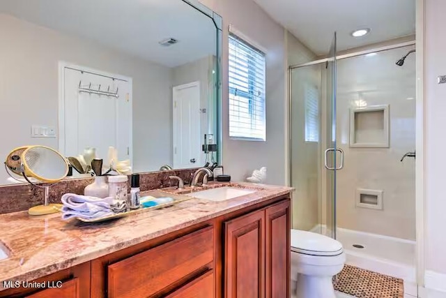 bathroom with tile patterned flooring, vanity, an enclosed shower, and toilet