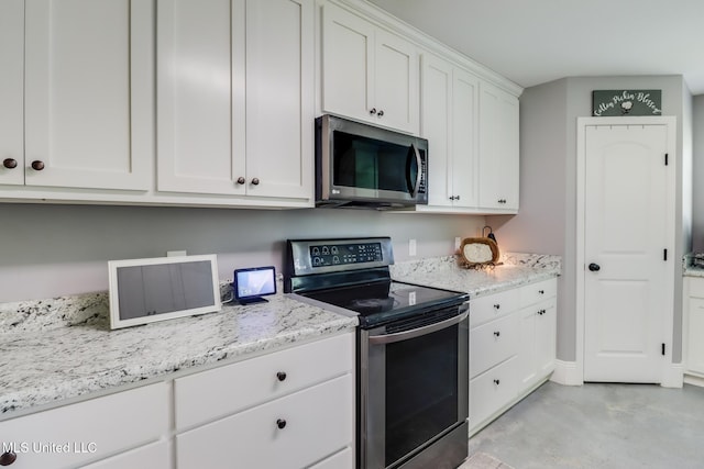 51 Decalb Oneal Rd, Perkinston, MS 39573 - kitchen featuring appliances with stainless steel finishes, white cabinetry, concrete flooring, and light stone counters