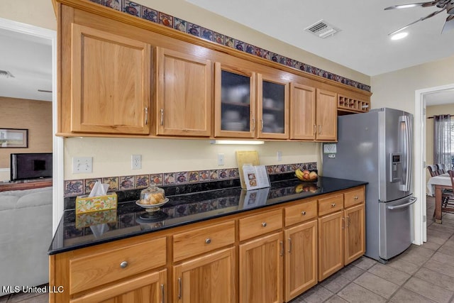 kitchen with stainless steel refrigerator with ice dispenser, visible vents, glass insert cabinets, a ceiling fan, and light tile patterned flooring