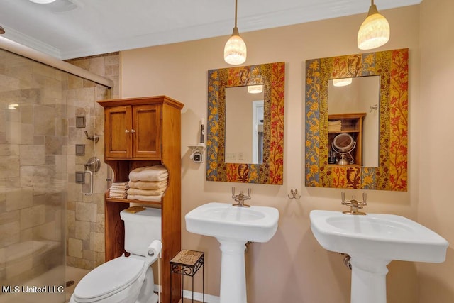 bathroom featuring a sink, crown molding, a shower stall, and toilet