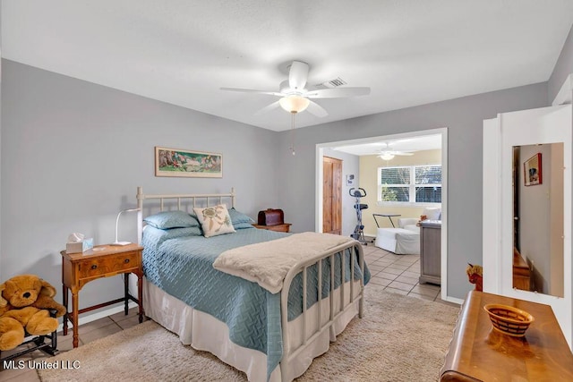 bedroom with baseboards, ceiling fan, ensuite bath, and light tile patterned floors