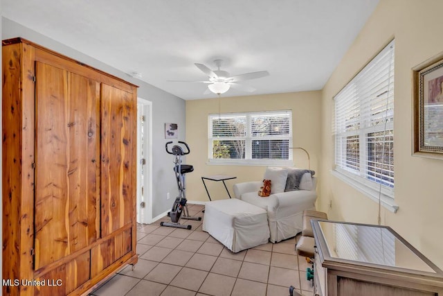 living area with ceiling fan, baseboards, and light tile patterned floors