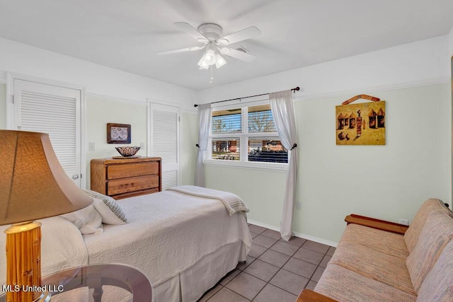 tiled bedroom with ceiling fan and baseboards