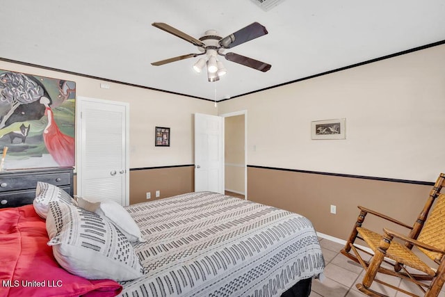 tiled bedroom with ornamental molding, ceiling fan, and baseboards