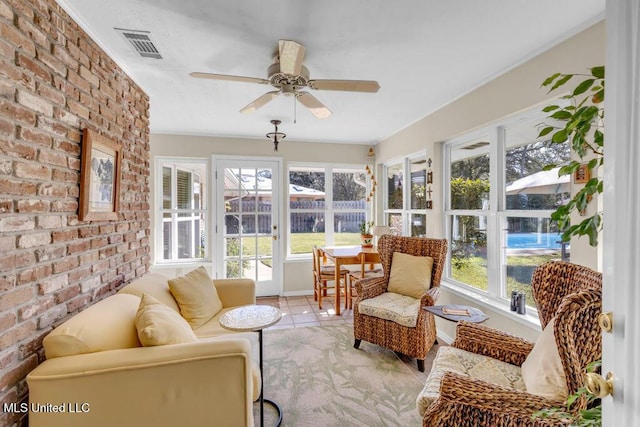 sunroom with a ceiling fan and visible vents