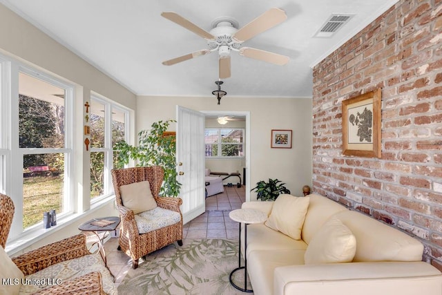 sunroom with plenty of natural light, visible vents, and a ceiling fan