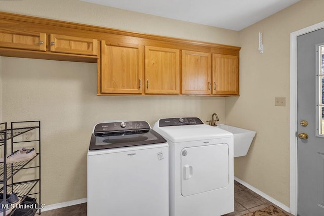 clothes washing area featuring tile patterned flooring, a sink, baseboards, cabinet space, and washing machine and clothes dryer