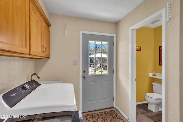 laundry area with washer / dryer, light tile patterned floors, baseboards, and cabinet space