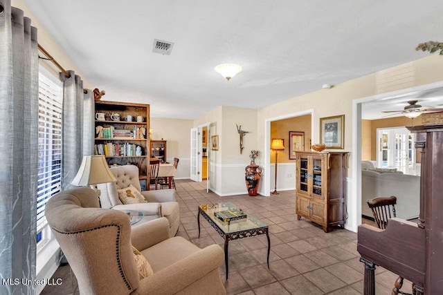 living area featuring ceiling fan, visible vents, and tile patterned floors