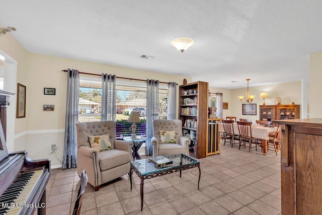 sitting room with visible vents, a notable chandelier, baseboards, and light tile patterned floors