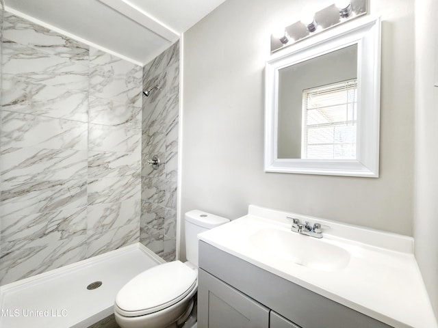 bathroom featuring toilet, a shower stall, and vanity