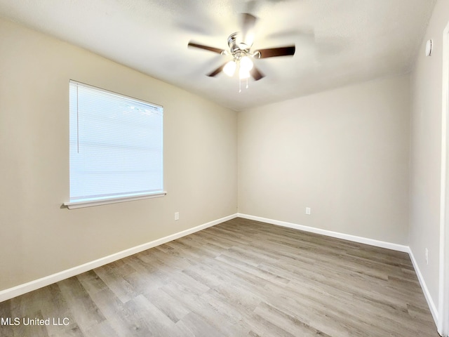 unfurnished room featuring ceiling fan, baseboards, and wood finished floors