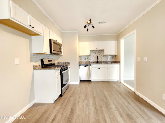 kitchen with appliances with stainless steel finishes, a sink, visible vents, and white cabinetry