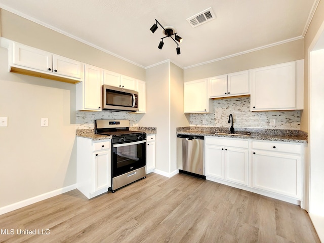 kitchen with stone countertops, stainless steel appliances, a sink, visible vents, and white cabinetry