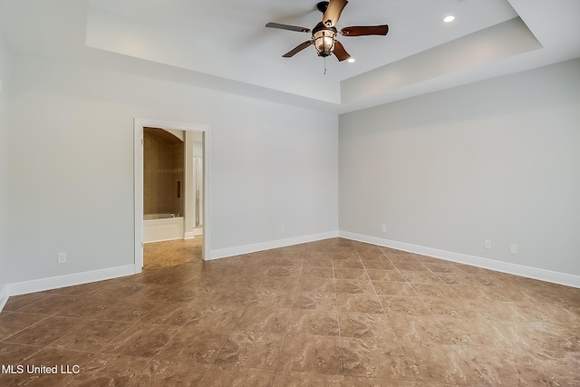 unfurnished room featuring a tray ceiling and ceiling fan