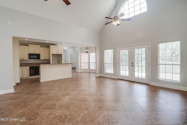 unfurnished living room with high vaulted ceiling, ceiling fan, and french doors