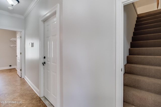 hall featuring light tile patterned floors and ornamental molding