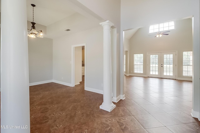 spare room with french doors, plenty of natural light, a high ceiling, and ornate columns