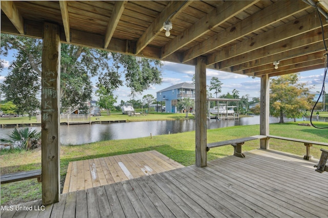 wooden deck with a yard and a water view