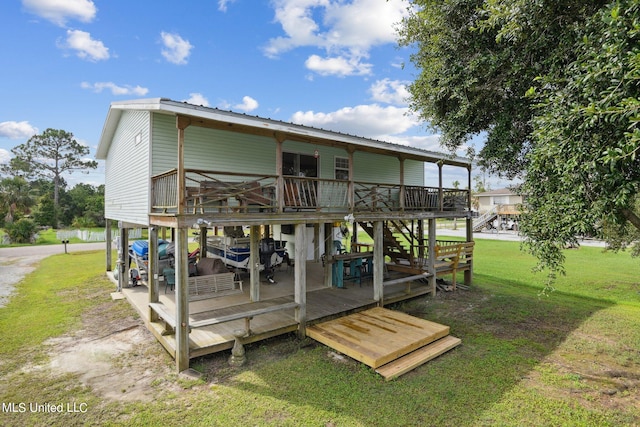 rear view of house featuring a wooden deck and a lawn