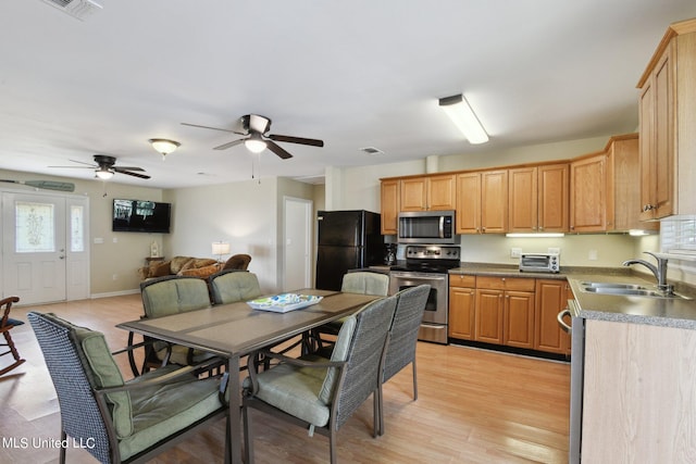 kitchen featuring light hardwood / wood-style flooring, stainless steel appliances, sink, and ceiling fan