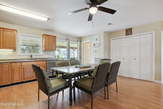 dining room with ceiling fan, sink, and light wood-type flooring